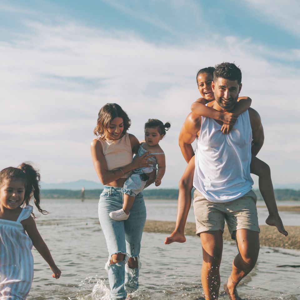 Familia corriendo por la playa durante sus vacaciones